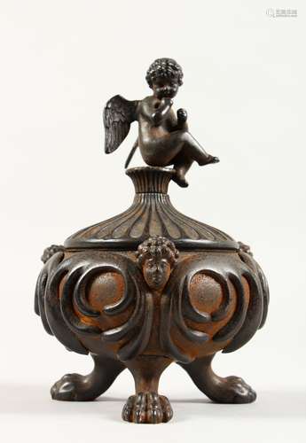 AFTER THE ANTIQUE. A CIRCULAR IRON INKWELL AND COVER, with cupid and masks, on claw feet. 4.5ins