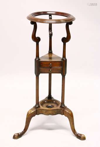 A GEORGE III STYLE MAHOGANY WASHSTAND, with a circular bowl aperture, two drawers, on three