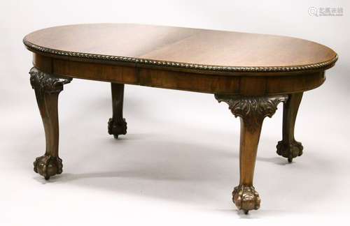 A GEORGIAN STYLE MAHOGANY EXTENDING DINING TABLE WITH TWO LEAVES, with rounded ends, on carved