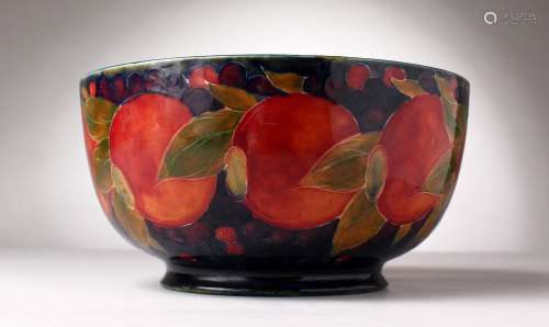 A LARGE MOORCROFT POTTERY CIRCULAR FRUIT BOWL, pomegranate and fruit on a blue ground. W.