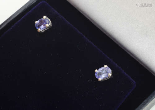 A pair of oval mixed cut tanzanite ear studs, in four claw settings with post backs, boxed