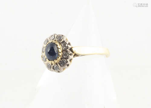 A continental sapphire and diamond cluster ring, all in yellow metal marked 750, with cabochon