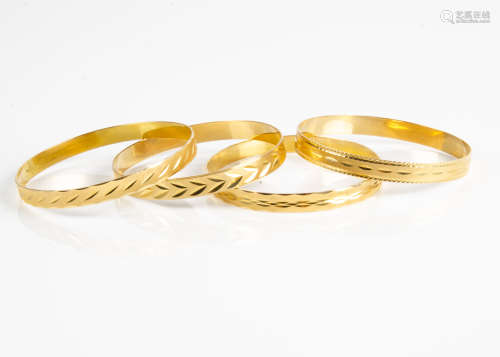 Four continental wheel engraved yellow metal bangles, marked 750, 56g