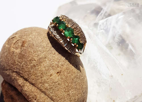 An emerald and diamond 14K marked dress ring, the five mixed round cut claw set graduated emeralds
