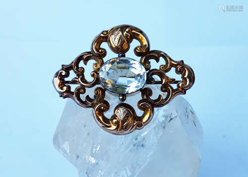 A Victorian yellow metal and rock crystal oval brooch, the oval mixed cut stone in a scroll