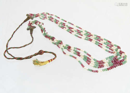 A mid 20th Century Indian multi strand ruby, emerald and seed pearl necklace, the polished emerald