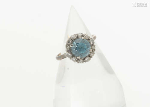 A zircon and diamond cluster dress ring, the circular mixed cut blue zircon in a four claw setting