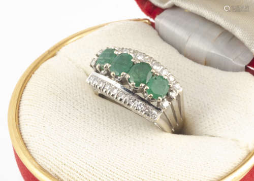 A continental emerald and diamond dress ring, the four oval mixed cut claw set emeralds flanked by a