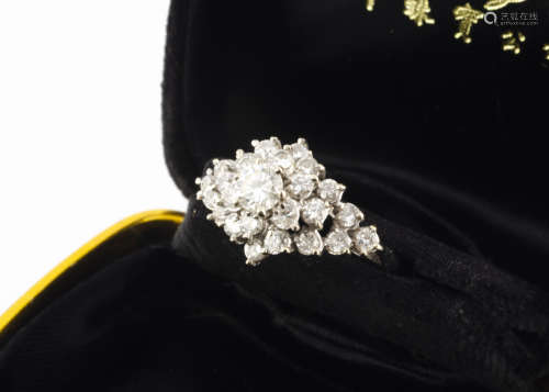 A late 20th Century continental diamond cluster ring, the central brilliant cut diamond in claw