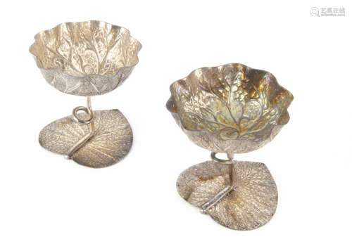 A pair of early 20th Century Middle Eastern white metal dishes, with leaf base and stem support