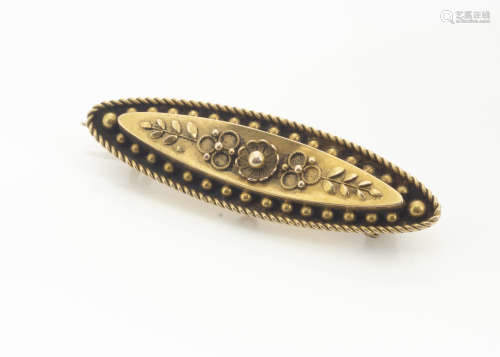 A 15ct gold oval shaped Victorian brooch, with central floral design within a sunken centre with