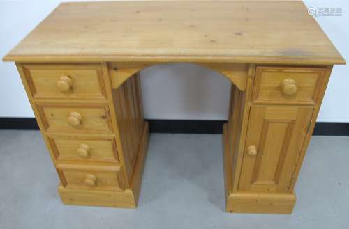 A contemporary pine knee hole desk, four short drawers to one side, one short and one covered to the