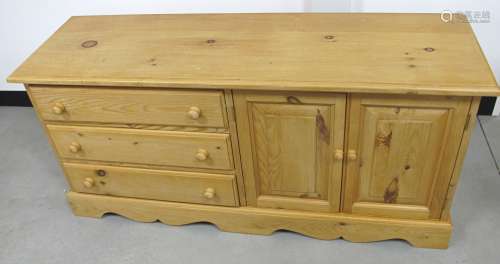 A contemporary pine cabinet, three long drawers and two panelled cuboard doors to opposite side,