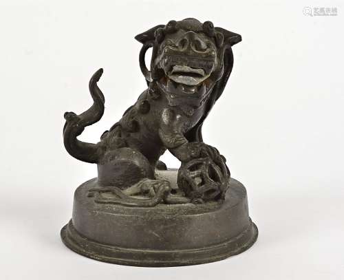 A 19th Century Chinese bronze figurine, modelled as a male dog of Fo, on a circular base with