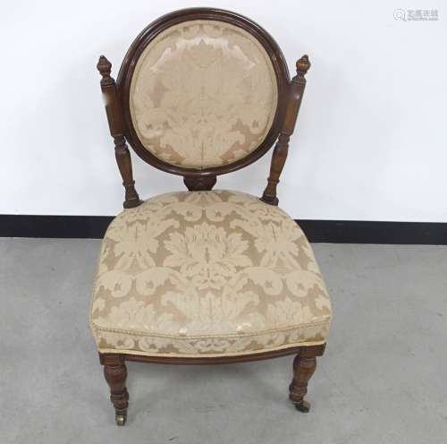 A late Victorian walnut framed nursing chair, circular back supported by two turned columns, blush