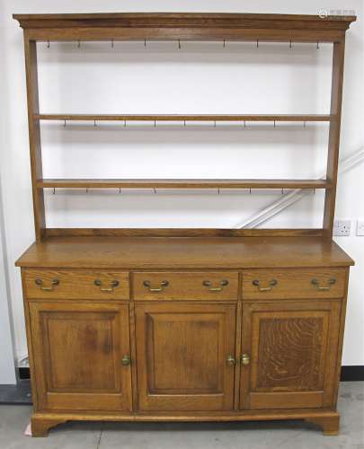 A 20th Century solid oak dresser, open back with two shelves, the base with three short drawers