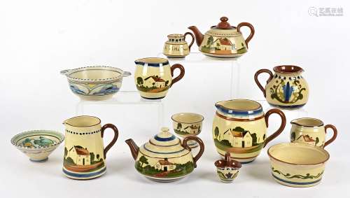A quantity of Devonware terracotta motto decorated, including teapots, leamonade jugs, milk jugs and