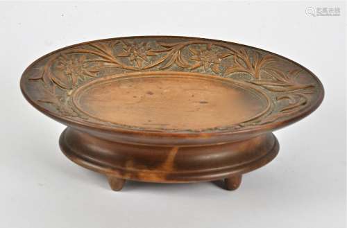 A Black Forest musical fruit bowl, carved in relief with a border of flowers and foliage, diameter