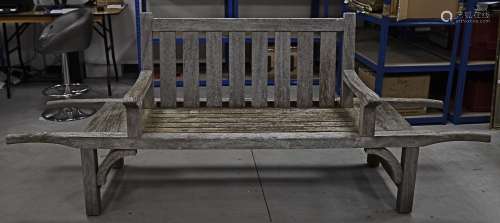 A contemporary slatted garden bench, with extending barrow like handles, the four legs with arch