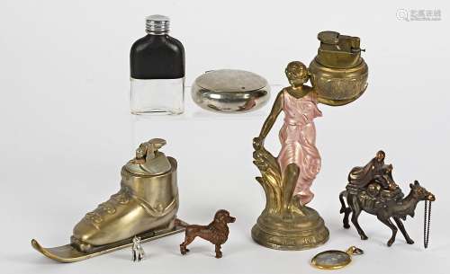 Three novelty lighters, modelled as a ski boot, a camel rider and a woman carrying a basket,