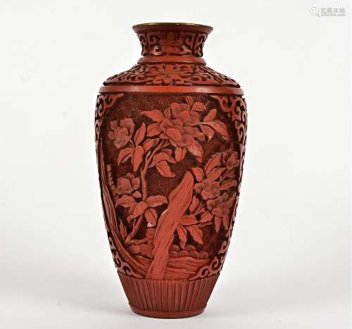 A cinnabar lacquer vase, with a depiction of plantlife rising above rocks, height 21cm