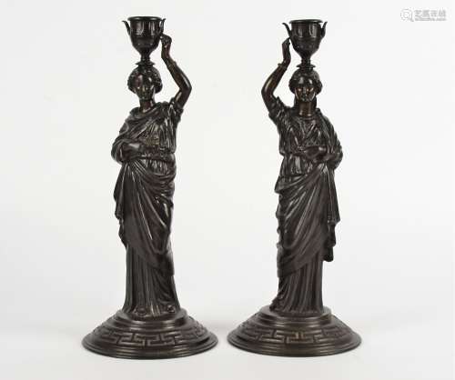 A pair of Verlag Bei Zimmermann Neo-Classical spelter candlestick holders, taking the form of female