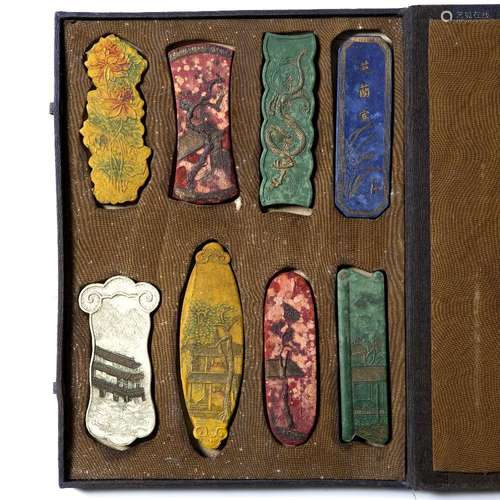 Cased set of eight ink stones Chinese in varying colours depicting houses, flowers and dragons the