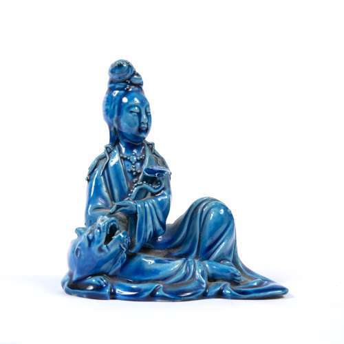 Blue glazed figure of Guanyin Chinese in a recumbent position, with a ruyi sceptre under one arm,