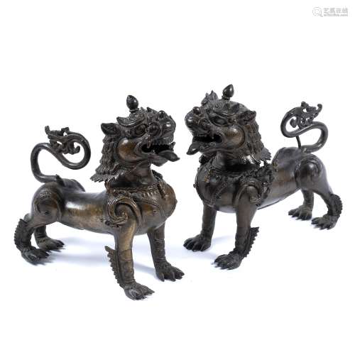 Pair of bronze lions Burmese, 19th Century standing four square, with breast-plate mount with a bell