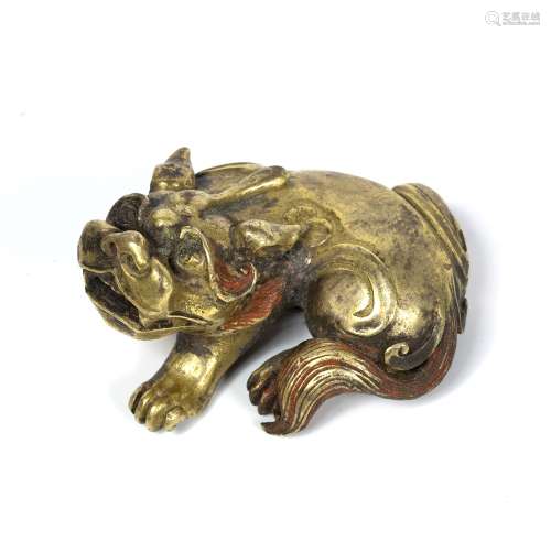 Solid gilt bronze recumbent Buddhist lion Chinese, 17th/18th Century the lion looking over it's left