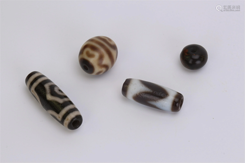 FOUR TIBETAN DZI AGATE BEADS