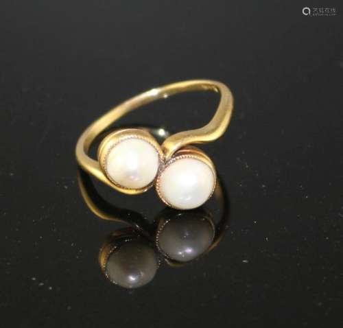 A 20th century 18ct and two stone cultured pearl set crossover ring, size O, gross weight 3.3 grams.