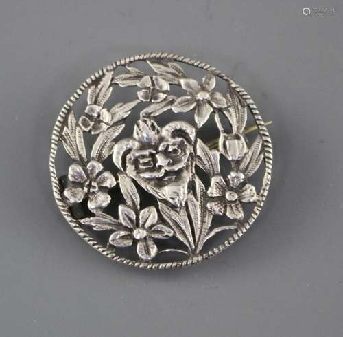 A late Victorian pierced white metal brooch, decorated with central mask amid foliage, makers mark