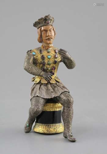 An Austro-Hungarian gilt and white metal figure of a seated knight, with jewelled decoration and