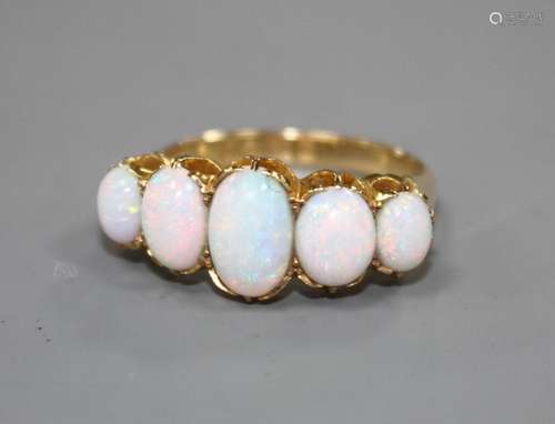 An Edwardian 18ct gold and graduated five stone white opal half hoop ring, size Q, gross 5.5