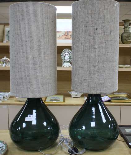 A pair of green glass lamp bases with cylindrical fabric shades, height overall 94cm, diameter