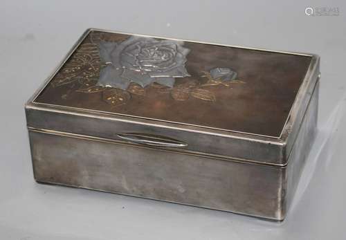 A Japanese silver, copper and gold cigarette box, Meiji period, decorated with a panel of roses,