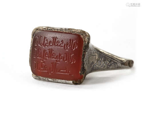 AN ISLAMIC NIELLOED SILVER RING SET WITH AN INSCRIBED CORNELIAN IN A SQUARE BEZEL, MOSUL AREA, 8TH-