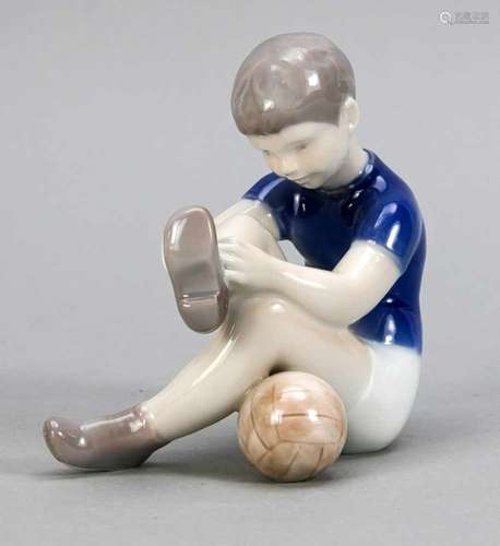 Football player tying his shoe, Bing & Grondahl, Copenhagen, 20th century, designed byClaire