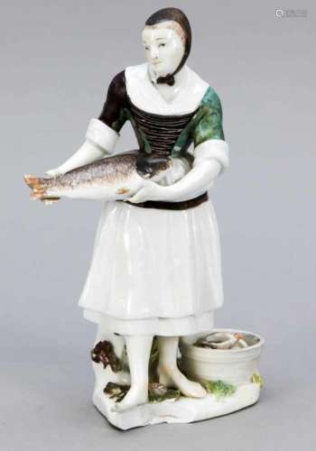 Fish seller, France, fisherwoman with big fish in her hands next to a basket, also filledwith