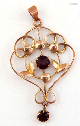 Yellow metal open work pendant centering a circular faceted amethyst with smaller matching dropper