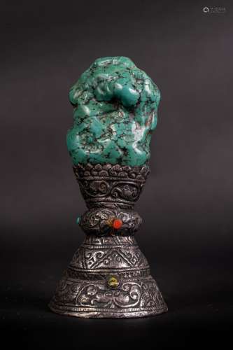 Arte Himalayana A turquoise stone mounted on a silver base decorated in relief with plant motifs Ti