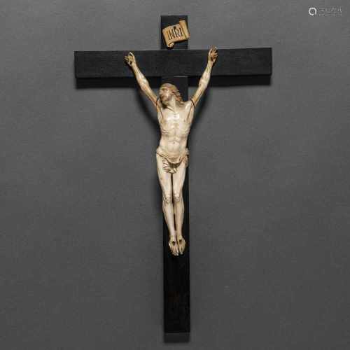 Figura de Cristo crucificado de cuatro clavos en marfil tallado sobre cruz latina en madera. Siglo