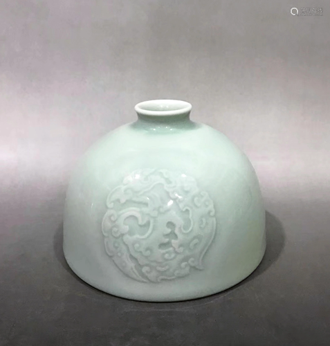 A CARVED CELADON GLAZED PORC…