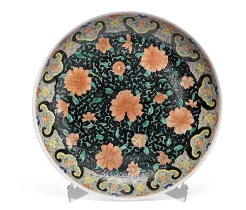 A Chinese black-ground famille rose porcelain dish. Mark of Yongzheng, but 19th century. Diam. 34 cm.
