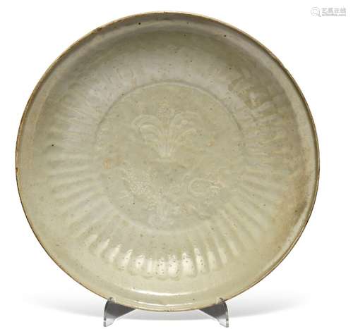 A Chinese late Ming dish with pale celadon glaze and slip decoration with flowers and lobed rim. Ming 1368-1644. Diam. 31 cm.