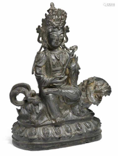 A Chinese bronze figure of a Guanyin seated on a snow lion. Ming 1368–1644. Weight 2581 gr. H. 28 cm.