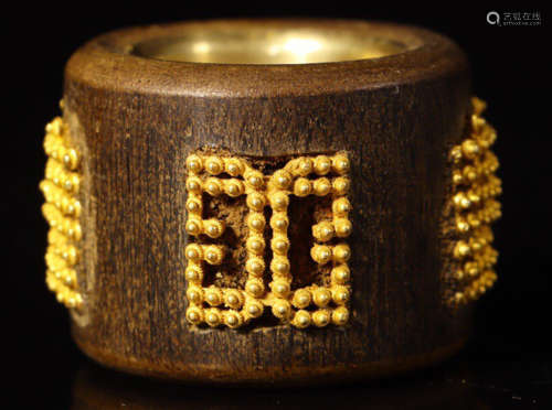 A CHENXIANG WOOD RING CARVED WITH AUSPICIOUS PATTERN AND EMBEDED WITH GOLD