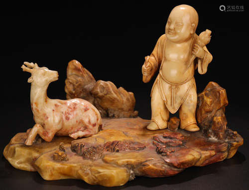 A SOAPSTONE CARVED FIGURE AND DEER