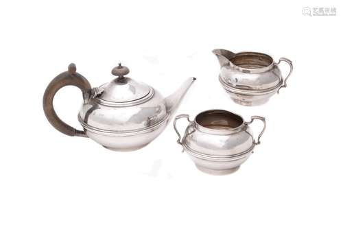 A silver three piece compressed circular tea set by Charles Boyton & Son Ltd.